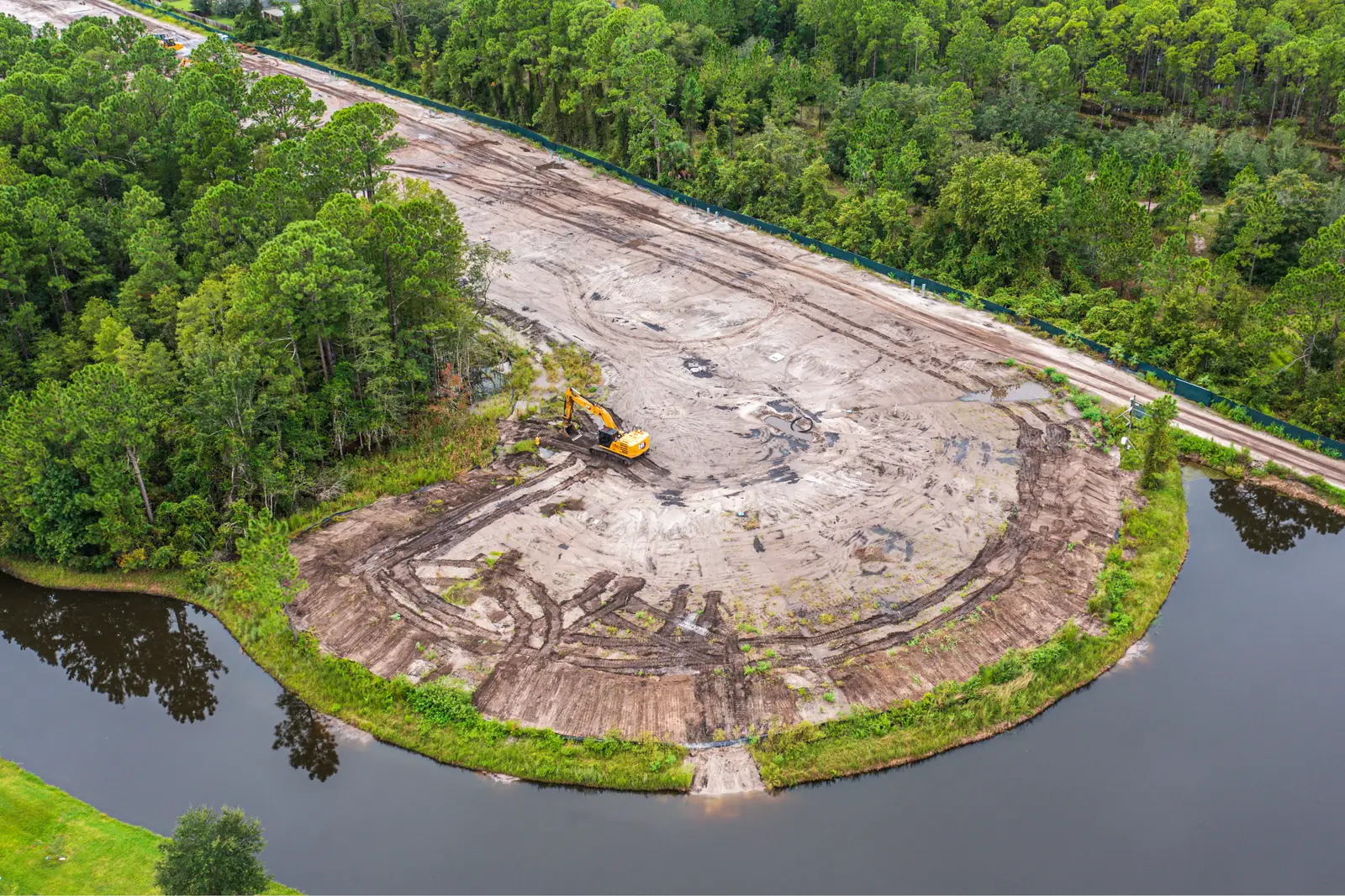 Monthly drone progress photo of a graded homesite pad bordered by retention ponds at a 55+ manufactured home community near St. Augustine Florida
