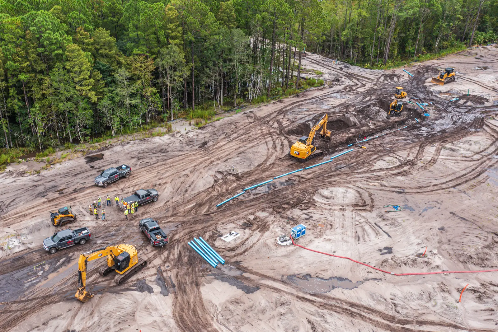 Aerial construction progress photography of underground water main installation and pipe laying crews, Coquina Crossing expansion Elkton FL