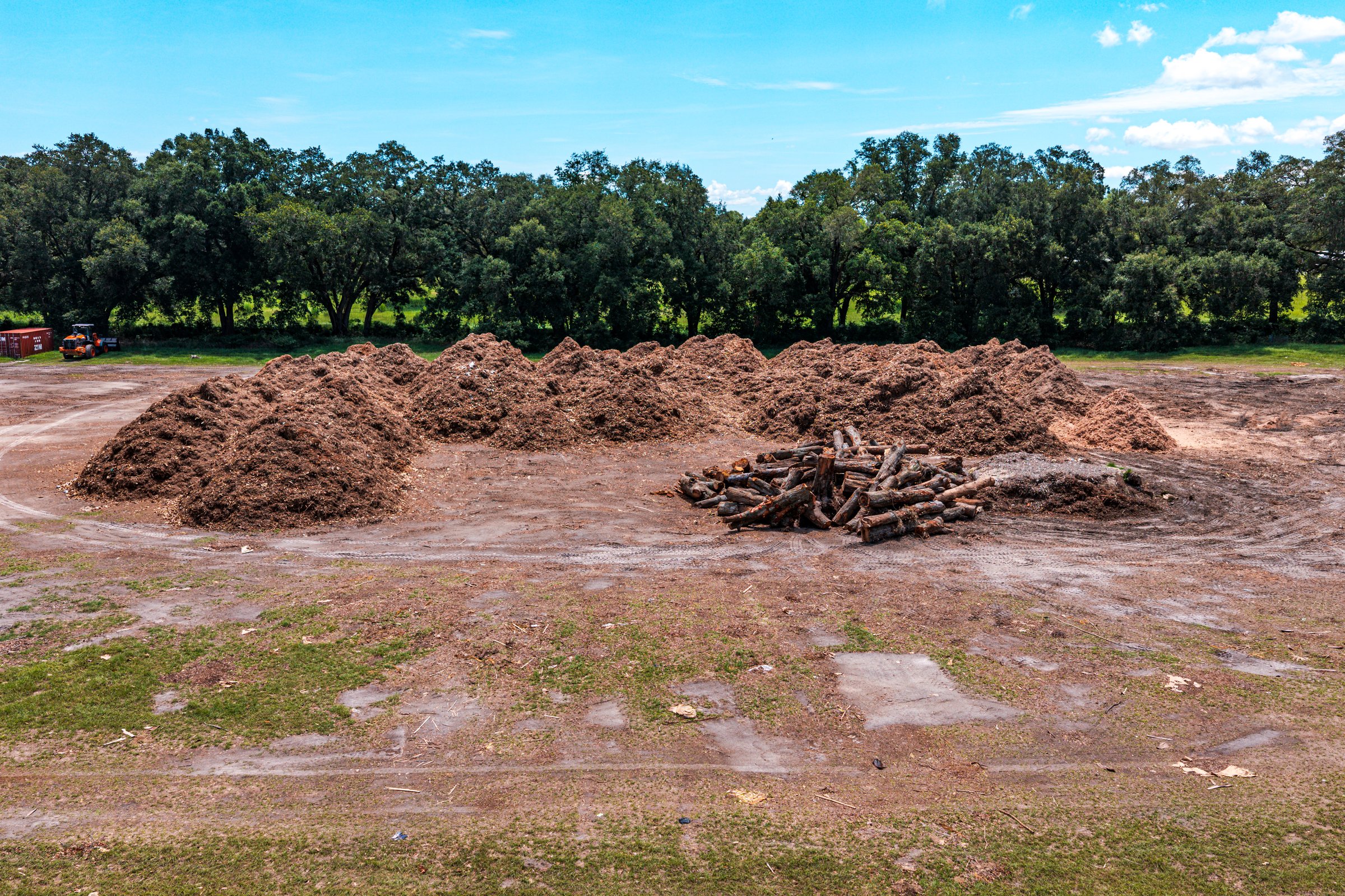 Cleared pad — mulch stockpile and site access road