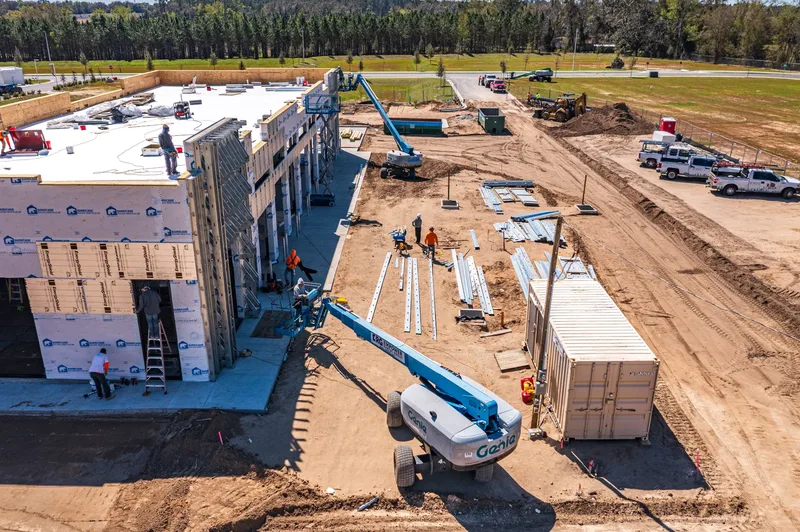 Aerial drone photo of a retail construction site in Alachua, FL — completed building exterior and parking lot