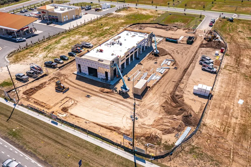 Aerial drone photo of a retail construction site in Alachua, FL — early construction phase with foundation work