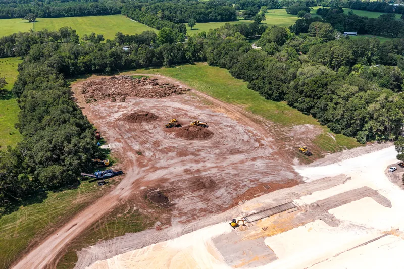 Aerial drone photo of the Newberry wastewater treatment plant expansion site — existing facility and cleared land, Newberry, FL