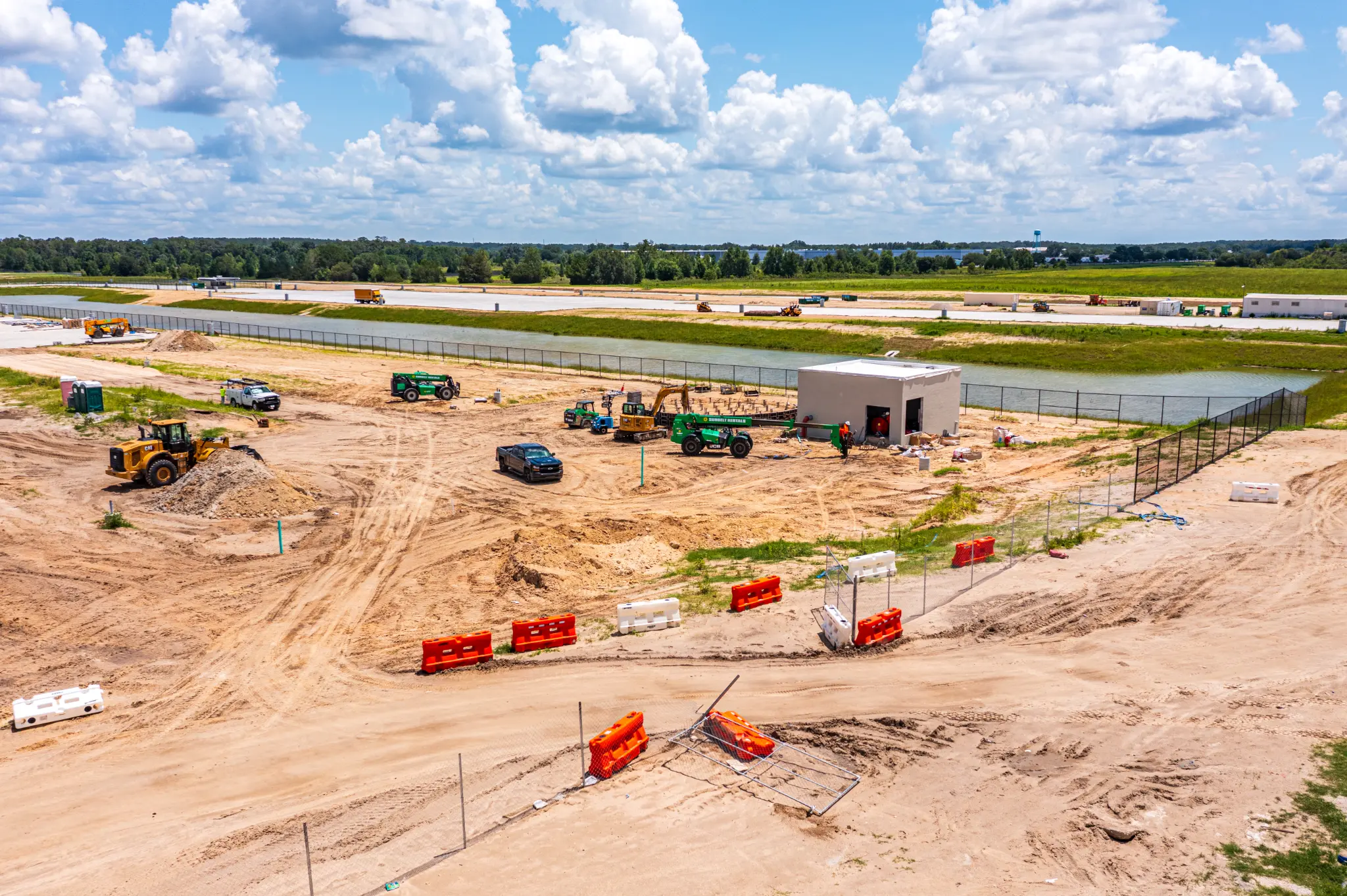 Aerial view of active sitework, stormwater pond, and heavy equipment at the Ben E. Keith Foods construction site in Alachua, FL